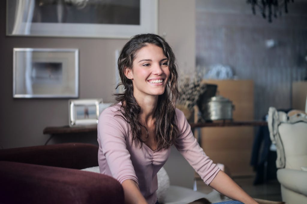 Joyous Woman Sitting On Maroon Couch